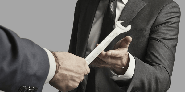 An auditor being handed a spanner.